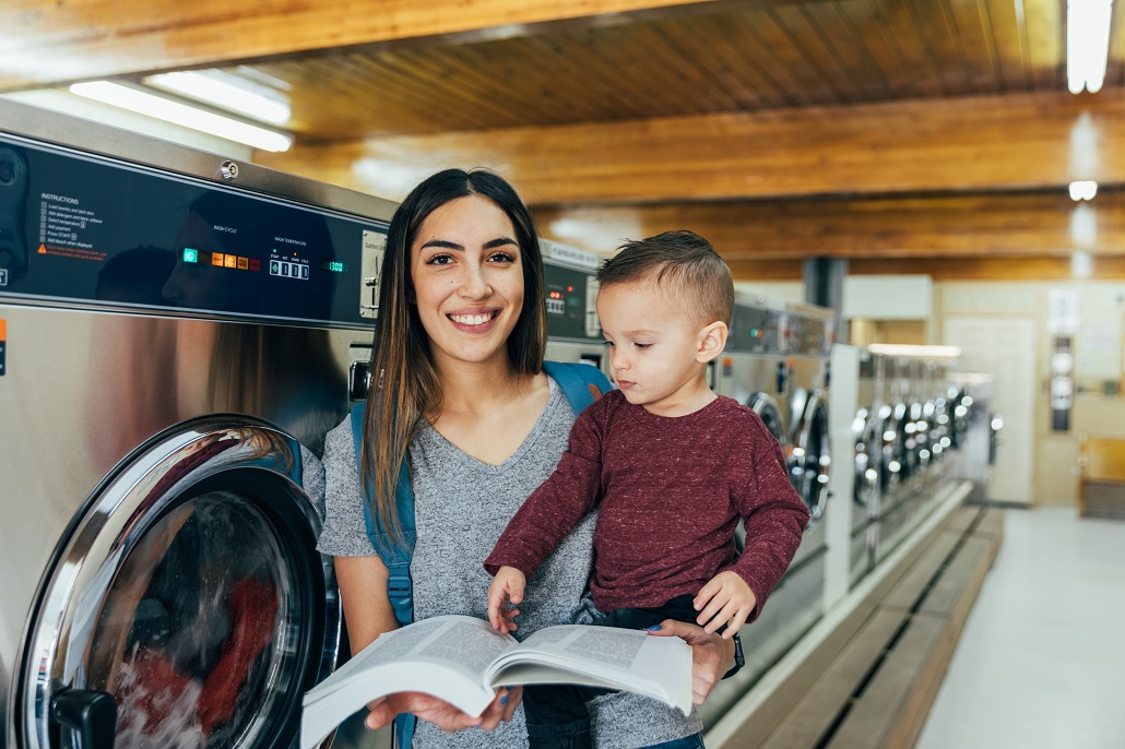 Woman holding son and reading book after returning to college as an adult