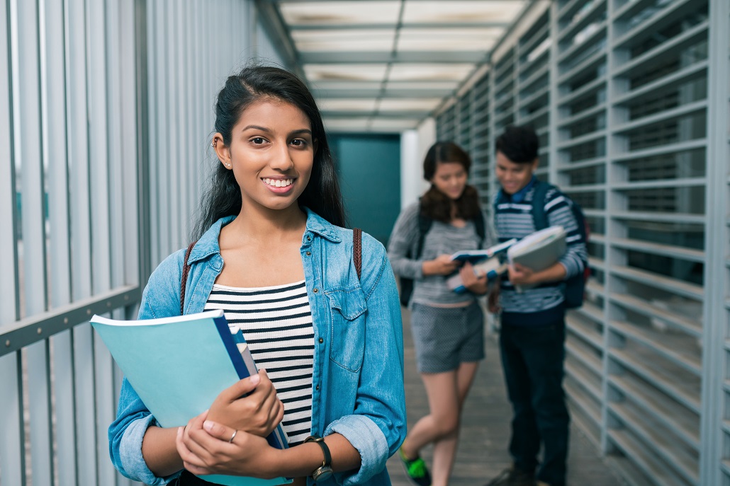 Student holding books in hallway