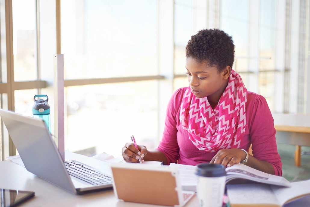 Woman using laptop to research how to pay for graduate school
